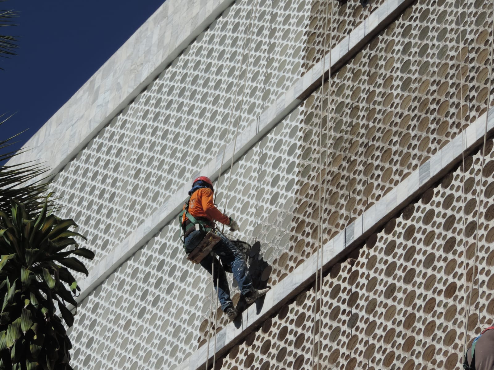 Equipe da ENGECRON limpando fachada de cobogó em prédio comercial na Asa Sul com acesso por rapel